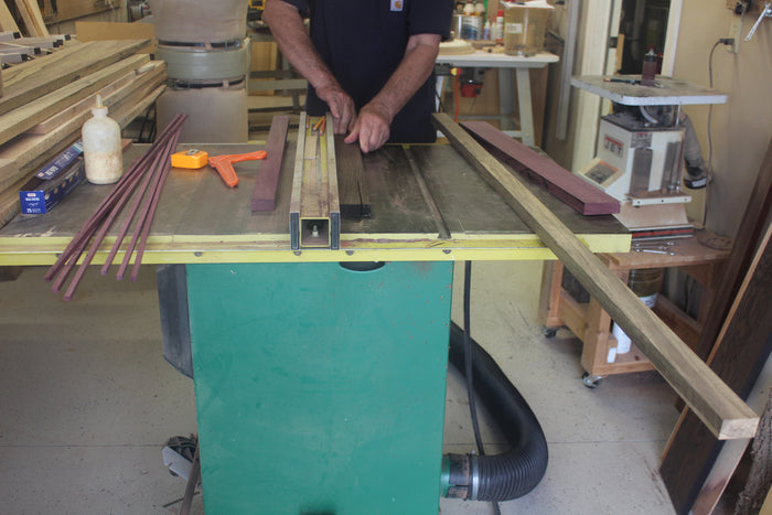 Person using a table saw in a workshop setting