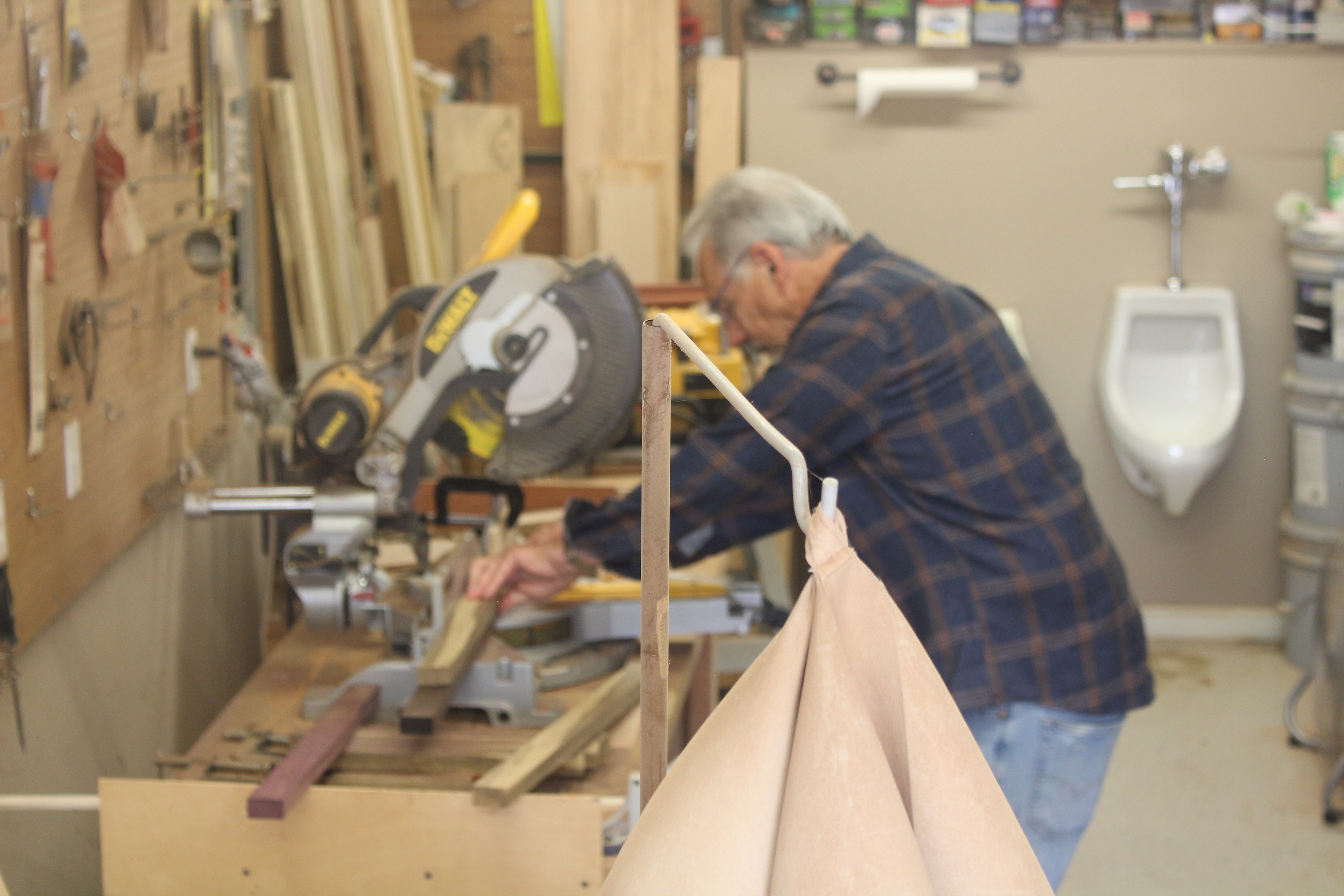 Man working with a circular saw in a workshop crafting pieces with exotic wood.